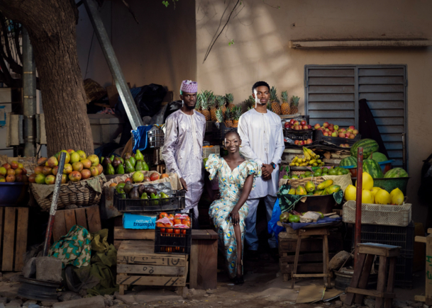 Three people in front of a food market stall