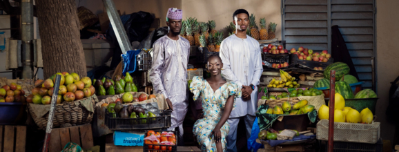 Three people in front of a food market stall