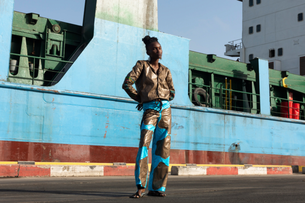 Woman posing in front of a container ship