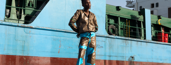 Woman posing in front of a container ship