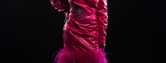 Woman in a short pink dress with feather detail