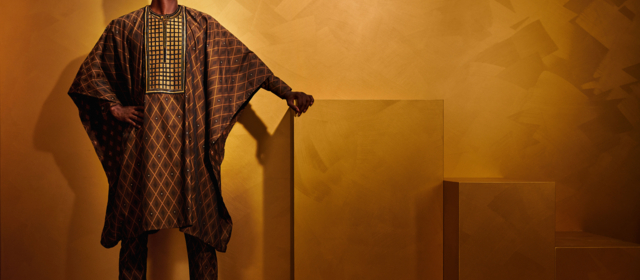 Stilvolle Darstellung eines Mannes in einem traditionellen braunen Gewand von Getzner Textil vor einem goldenen Hintergrund.